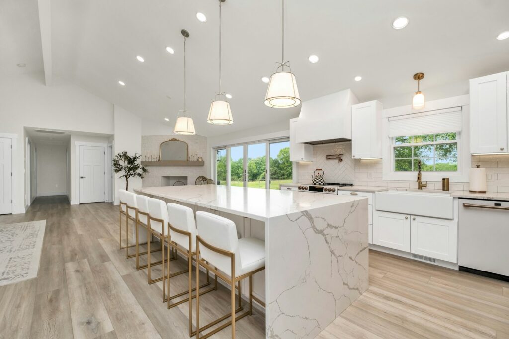 Large kitchen with a marble island and white cabinets, showing a classic white kitchen style