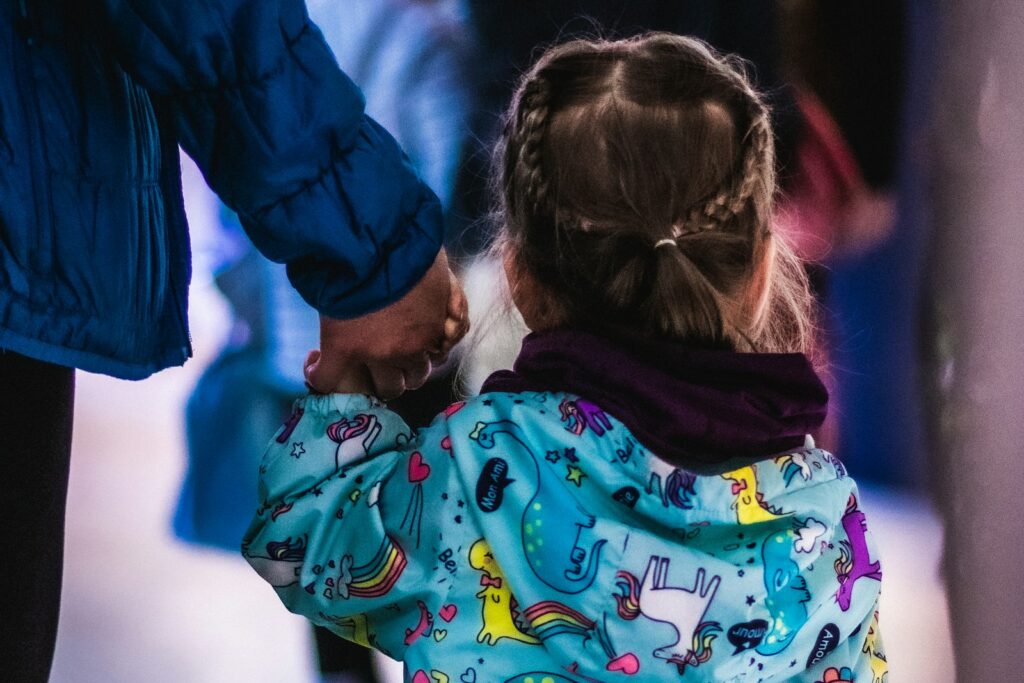 Little girl holding the hand of an adult, reflecting the support foster carers provide