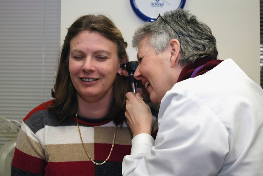 Doctor examining a patient's ear during a check-up, similar to an audiology ear inspection