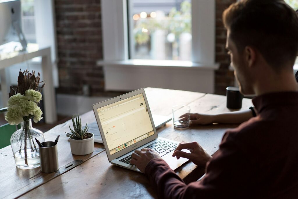 Man using a laptop in an office, where elearning completion data might be tracked