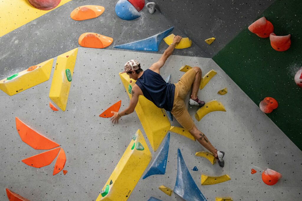Man bouldering on an indoor climbing wall at Boulder Line in Montpellier