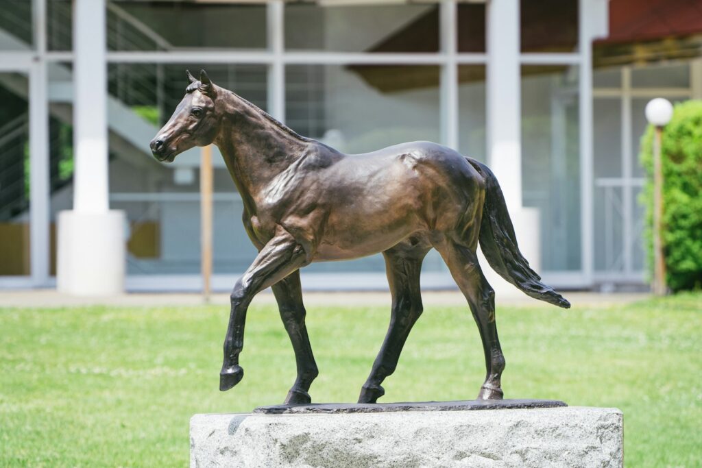Elegant bronze horse statue on a stone pedestal, showing the proportions sculptors must capture